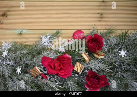 Belle photographie image romantique de noël avec guirlande de roses rouges fraîches et de décoration avec des chocolats de luxe en bois et l'arrière-plan de l'espace de copie Banque D'Images