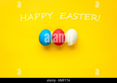 Trois oeufs de pâques bijou isolé sur un fond orange. avec les mots joyeuses Pâques. Banque D'Images