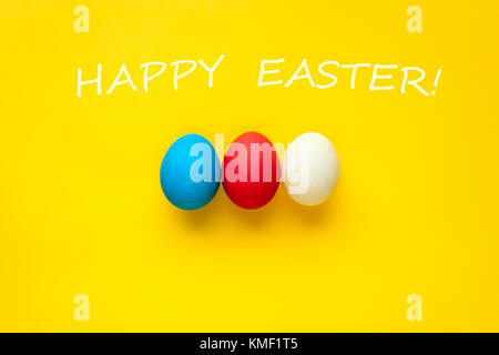 Trois oeufs de pâques bijou isolé sur un fond orange. avec les mots joyeuses Pâques. Banque D'Images