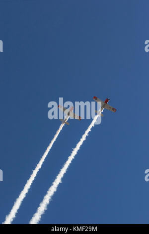 Deux des avions volant avec hélice traînée de fumée dans le ciel bleu profond Banque D'Images