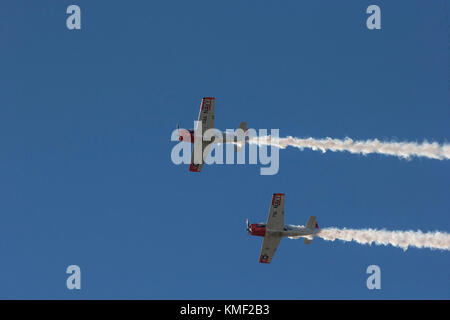 Deux des avions volant avec hélice traînée de fumée dans le ciel bleu profond Banque D'Images