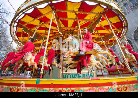 Les Choristes à partir de la cathédrale d'Ely dans le Cambridgeshire obtenir un cadeau de Noël qu'ils get a free ride sur une 107 ans carousel le vendredi après-midi du 17 novembre que la cathédrale est titulaire d'un marché de Noël. Banque D'Images