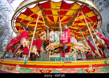 Les Choristes à partir de la cathédrale d'Ely dans le Cambridgeshire obtenir un cadeau de Noël qu'ils get a free ride sur une 107 ans carousel le vendredi après-midi du 17 novembre que la cathédrale est titulaire d'un marché de Noël. Banque D'Images