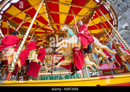 Les Choristes à partir de la cathédrale d'Ely dans le Cambridgeshire obtenir un cadeau de Noël qu'ils get a free ride sur une 107 ans carousel le vendredi après-midi du 17 novembre que la cathédrale est titulaire d'un marché de Noël. Banque D'Images