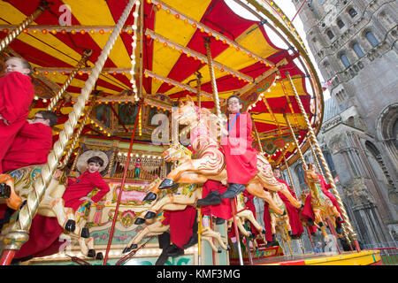 Les Choristes à partir de la cathédrale d'Ely dans le Cambridgeshire obtenir un cadeau de Noël qu'ils get a free ride sur une 107 ans carousel le vendredi après-midi du 17 novembre que la cathédrale est titulaire d'un marché de Noël. Banque D'Images