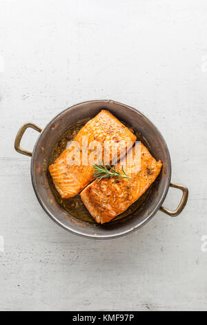 Rôti de saumon steak. Pavé de saumon rôti en casserole sur fond blanc en béton. Banque D'Images