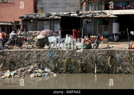 Monts de sacs en plastique, de la poussière et s'accumuler au fil des années dans le lit d'une rivière à côté de gens trier les déchets généraux Banque D'Images