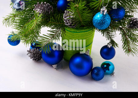 Centre de table de Noël avec des ornements bleu, l'argent des pommes de pin et branches de sapin en vase vert Banque D'Images