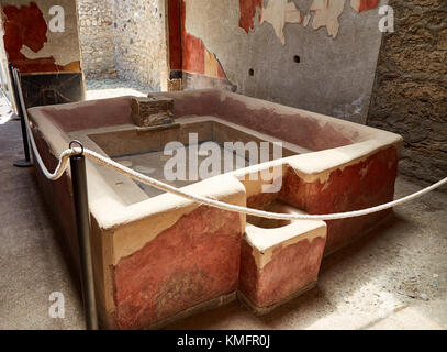 Baignoire ancienne avec un pas pour s'asseoir conservé après une catastrophe dans l'une des maisons de Pompéi, italie Banque D'Images