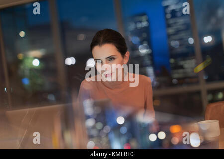 Femme d'affaires travaillant tard au bureau la nuit avec un ordinateur portable Banque D'Images