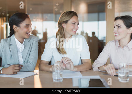 Des femmes d'affaires souriantes parlent dans la salle de conférence Banque D'Images