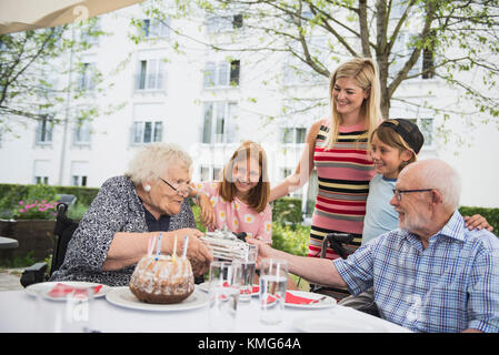 Couple senior avec cadeau à la table à manger Banque D'Images