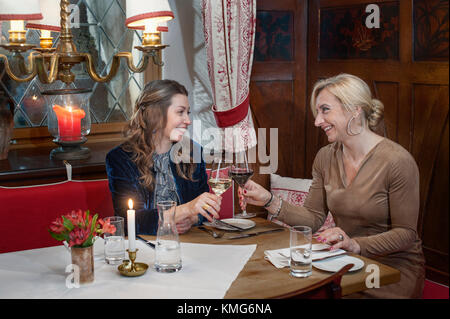 Deux femmes toasting with wine in restaurant Banque D'Images