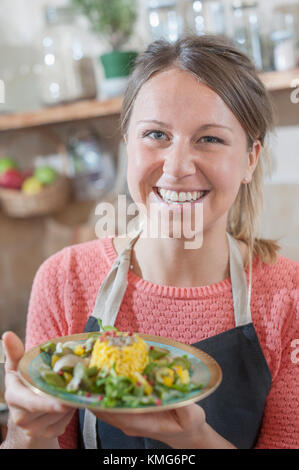 Portrait de femme avec plat de riz garnie dans la main Banque D'Images