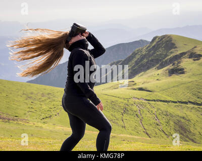 Femme profitant de l'exploration de la réalité virtuelle sur la montagne Banque D'Images