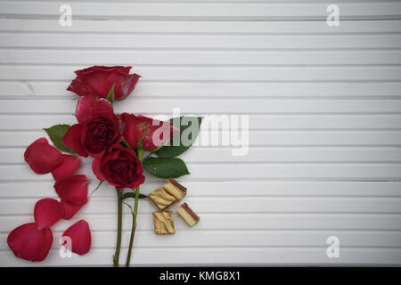 Photographie image romantique avec des roses rouges et des fleurs réelles des chocolats de luxe sur fond de bois blanc avec copie espace idéal pour la saint valentin Banque D'Images