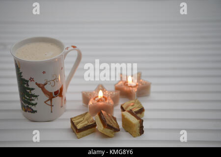 Photographie image de Noël avec une pétillante boisson chaude dans le renne imprimer mug avec des bougies et de chocolat de luxe sur fond de bois blanc Banque D'Images