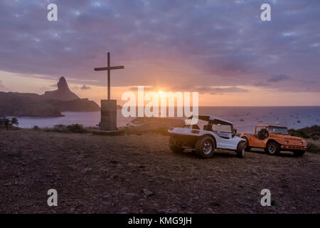 Buggies et coucher du soleil à partir de la chapelle de São Pedro dos Pescadores avec Morro do Pico sur arrière-plan - Fernando de Noronha, Pernambouc, Brésil Banque D'Images