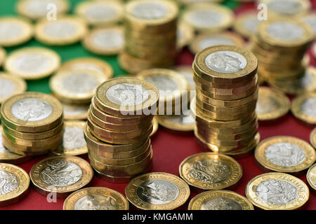 Pièces livre en grande quantité sur un thème de Noël rouge et vert l'arrière-plan. Les dépenses de Noël et des pièces dans un établissement saisonnier Banque D'Images