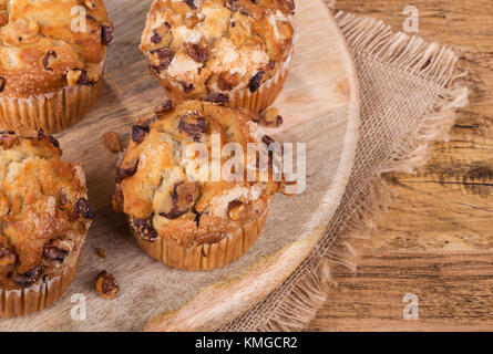 Des petits muffins aux bananes et noix sur un plateau en bois Banque D'Images