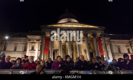 Trafalgar Square, Londres, 7 décembre 2017. Les gens regardent la cérémonie en face de la Galerie nationale. L'assemblée annuelle de l'éclairage de l'arbre de Noël de Trafalgar Square cérémonie a lieu sur la place, avec les touristes et les Londoniens observant l'interrupteur sur officiel, ainsi que Noël et du chant choral dans l'atmosphère de fête. Credit : Imageplotter News et Sports/Alamy Live News Banque D'Images