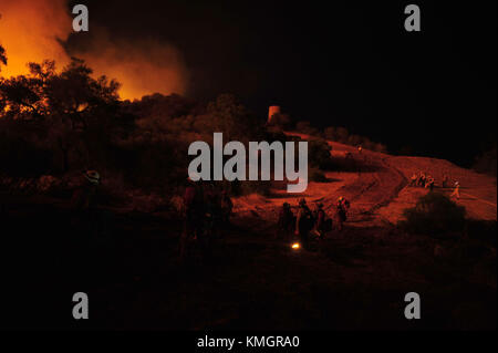 Ojai, Californie, États-Unis. 7 décembre 2017. Les équipes manuelles des détenus de CAL Fire attendent le long d'une ligne de bulldozer, regardant le Thomas Fire approcher Camp Ramah dans l'ouest d'Ojai. Crédit : Neal Waters/ZUMA Wire/Alamy Live News Banque D'Images