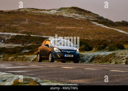 Haytor, Dartmoor, UK. 8 décembre 2017. Météo britannique. Une voiture conduit à travers un paysage avec une fine couche de neige près de The Haytor dans le Parc National de Dartmoor dans le Devon près de Bovey Tracey au lever du soleil. Crédit photo : Graham Hunt/Alamy Live News Banque D'Images