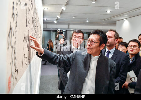 Paris, France. Dec 11, 2017. Zhang Xuguang (avant) introduit un morceau de sa calligraphie à l'Organisation des Nations Unies pour l'éducation, la science et la culture (UNESCO), siège à Paris, France, le 11 décembre, 2017. 'L'Aspirant à la paix--Zhang Xuguang Cursive de l'Exhibition' le coup d'ici lundi. Environ 50 pièces de calligraphie chinoise de Zhang Xuguang salue les visiteurs jusqu'au 16 décembre. Crédit : Chen Yichen/Xinhua/Alamy Live News Banque D'Images