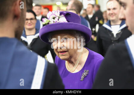 La reine Elizabeth II parle aux membres de l'équipage du navire, lors de la mise en service du HMS Queen Elizabeth, le plus grand et le plus puissant navire de guerre, dans la Royal Navy Fleet à Portsmouth Naval Base. Banque D'Images