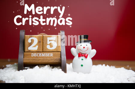 Santa Claus et Snow man Doll avec calendrier en bois fixé le 25 décembre sur fond rouge, concept de chrismas Banque D'Images