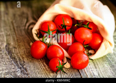 Tomates mûres rouges sortir de sac. vue rustique Banque D'Images