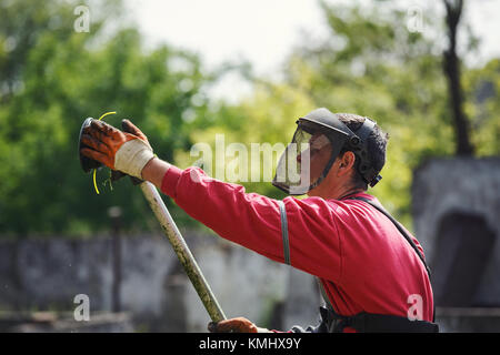 L'homme travailleur réparer la tondeuse string closeup Banque D'Images