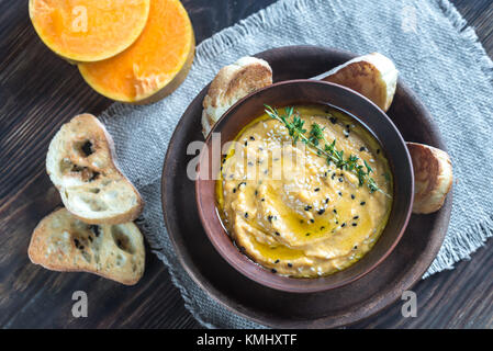 Bol de l'hummus de citrouille avec des tranches de pain grillé Banque D'Images