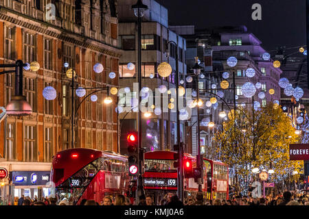 Oxford St décorations de Noël avec des bus de Londres, à Noël rempli avec les acheteurs de Noël marchant le long d'Oxford St, Londres, Royaume-Uni Banque D'Images