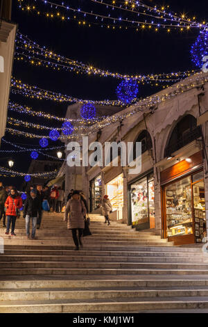 Allume les lumières de Noël sur le pont du Rialto, Venise, Italie dans la nuit avec des boutiques très éclairée et personnes marchant dans les étapes Banque D'Images