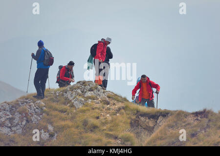 Groupe de personnes de différentes tranches d'âge et de l'ethnicité en montant sur le sentier de montagne au cours de la Randonnée Banque D'Images