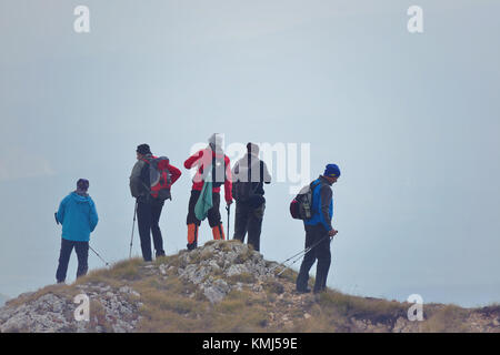 Groupe de personnes de différentes tranches d'âge et de l'ethnicité en montant sur le sentier de montagne au cours de la Randonnée Banque D'Images