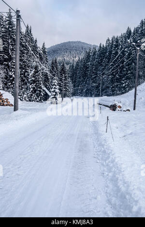 Paysage d'hiver avec la neige a couvert la route, forêt et colline en arrière-plan dans les montagnes Beskides près de Moravka village en République Tchèque Banque D'Images