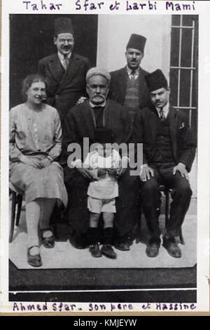 Cette image représente le portrait de famille de la famille Sfarinconnu, un groupe inconnu ou non identifié. La composition est typique de la photographie de famille, avec des individus regroupés, mettant en valeur des vêtements et des vêtements traditionnels. L'heure exacte et le contexte de la photo ne sont pas précisés, laissant l'identité des individus ouverte à l'interprétation. Banque D'Images