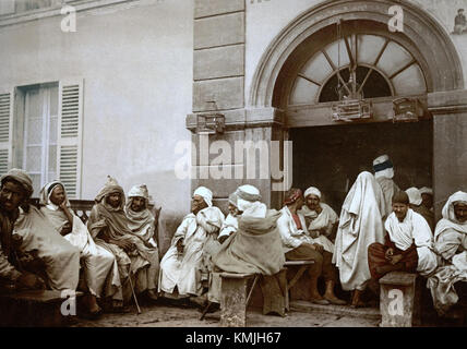 Une carte postale de 1899 représentant un café à Alger, reflétant l'atmosphère culturelle de la ville à la fin du XIXe siècle. L’image offre un aperçu de la vie sociale et des espaces urbains de l’époque. Banque D'Images
