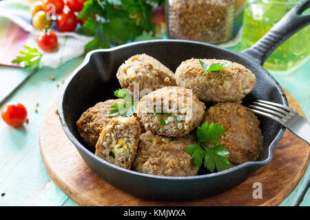Des boulettes avec la farce d'oeufs et de sarrasin. Poêle en fonte avec delicious fried escalopes, fines herbes et légumes sur la table de cuisine Banque D'Images