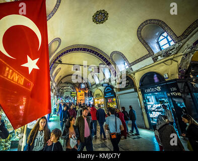 Touristes non identifiés visitant et faisant du shopping dans le Grand Bazar à Istanbul. Intérieur du Grand Bazar avec drapeau turc au premier plan. Istanbul Banque D'Images