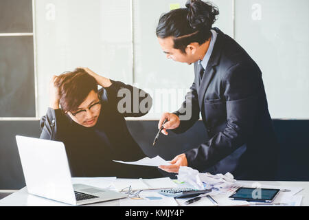 Mauvais patron asiatique en colère en criant à l'homme d'affaires triste déprimé employé réprimande de leader de l'équipe concept délai manqué Banque D'Images