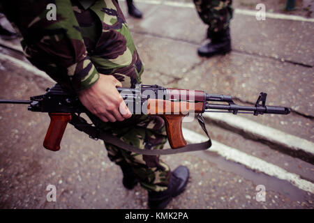 Soldat tenant un fusil automatique sur un champ de tir militaire Banque D'Images