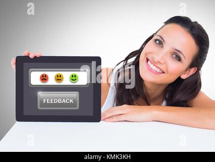Digital composite of Woman holding tablet avec satisfaction commentaires smiley icons Banque D'Images