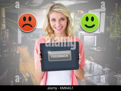 Digital composite of Woman holding tablet avec smiley commentaires icônes satisfaction Banque D'Images