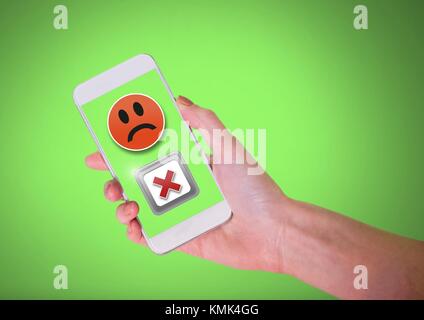 Digital composite of Hand holding phone avec smiley triste et négatif X mauvais bouton Banque D'Images