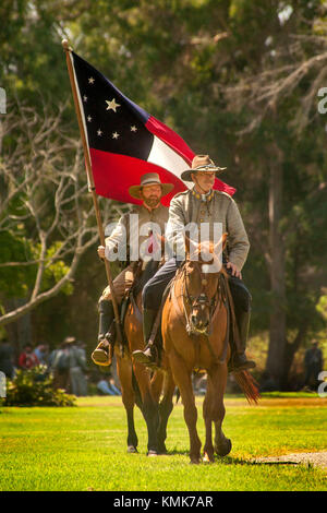 "Deux soldats confédérés' à cheval portent le drapeau national sur les premiers confédérés d'une guerre civile dans une reconstitution Huntington Beach, CA, Parc. Banque D'Images