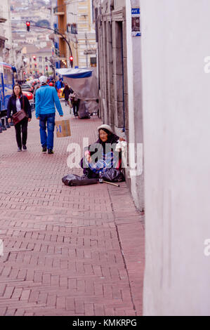 Quito, Équateur, 28 novembre, 2017 : des personnes non identifiées, marcher dans les rues à proximité d'une pauvre femme à l'intérieur de l'ail de vente de sacs de plastique au centre historique de la vieille ville de Quito, au nord de l'équateur Banque D'Images