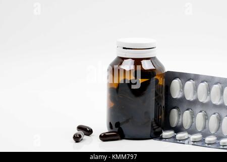 Capsule de vitamines en flacon en verre avec étiquette vierge et comprimés de suppléments en blister sur fond blanc. Bon complément des pilules pour femme b Banque D'Images